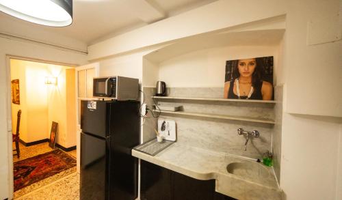 热那亚The Apartment Genova的厨房配有水槽和冰箱