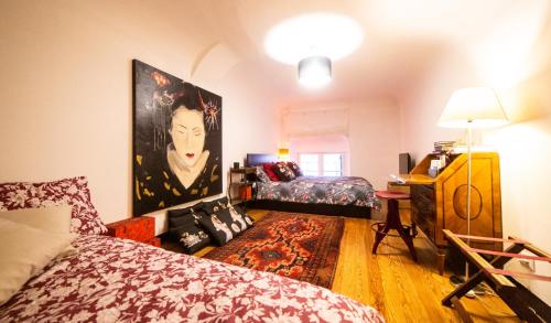 热那亚The Apartment Genova的卧室配有一张床,墙上挂有绘画作品