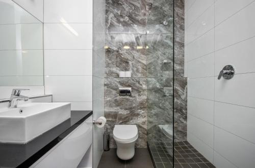 开普敦花园中心假日公寓酒店的浴室配有卫生间、盥洗盆和淋浴。