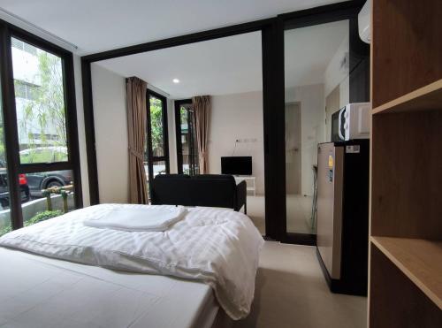 曼谷POP Heritage Residence的一间卧室配有一张床,厨房配有窗户