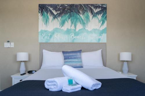 赫维湾谢利湾度假酒店的一间卧室配有一张床,上面有两条毛巾