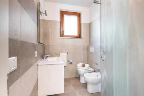 锡罗洛Dietro L'angolo Appartamenti的白色的浴室设有卫生间和水槽。