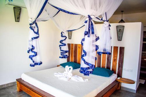 AmbondronaTiako Villas的一间卧室配有蓝色和白色窗帘的床