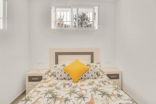 马拉加MILLION APARTAMENT的一间卧室配有一张黄色枕头的床