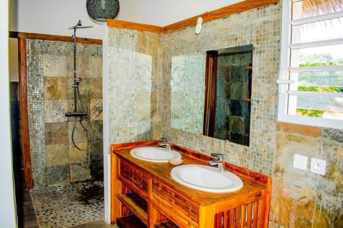 AmbondronaTiako Villas的一间带两个盥洗盆和淋浴的浴室