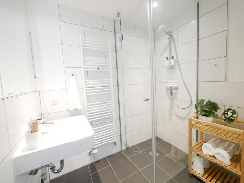 帕德博恩Zentral, modern, gemütlich mit Balkon & Parkplatz的白色的浴室设有水槽和淋浴。