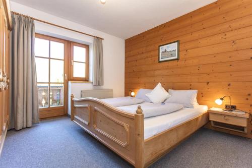 布利克森塔勒Haus Pfistererbauer的一间卧室设有木墙、一张床和一个窗户