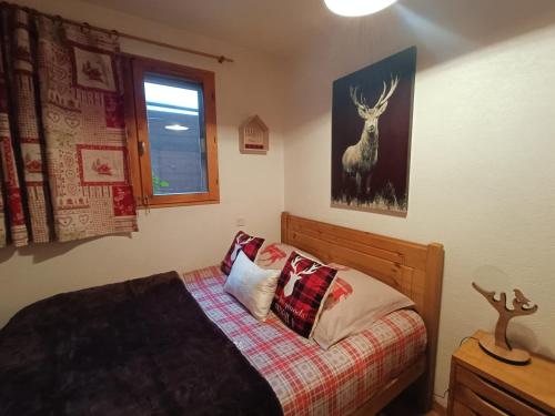 AigueblancheAppartement avec terrasse et parking Privé的卧室配有一张挂着鹿图的床铺。