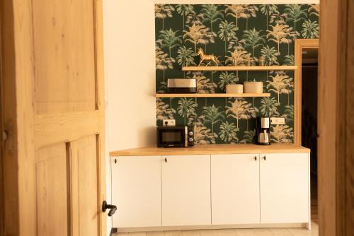 HollebekeVakantiewoning Dorp-28的厨房配有白色橱柜和植物壁纸