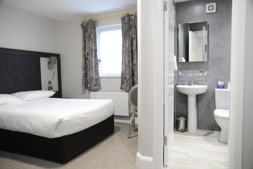 马罗喜百年休闲中心酒店的一间卧室配有床、水槽和卫生间