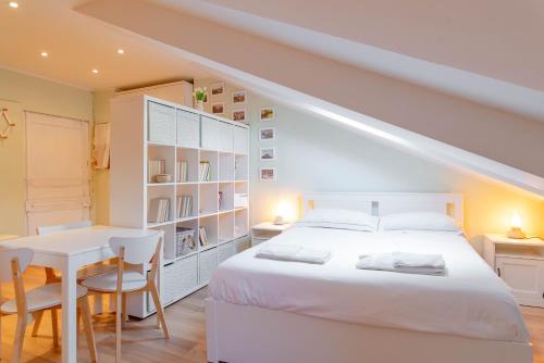 都灵Nella casa del pittore的卧室配有白色的床和桌椅