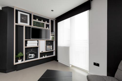伦敦基普酒店的客厅配有电视和黑色墙壁
