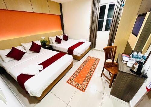 吉隆坡城市中心酒店的酒店客房设有两张床和一张桌子。