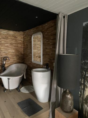 安锡“独特位置”舒适公寓的带浴缸和浴缸的浴室。