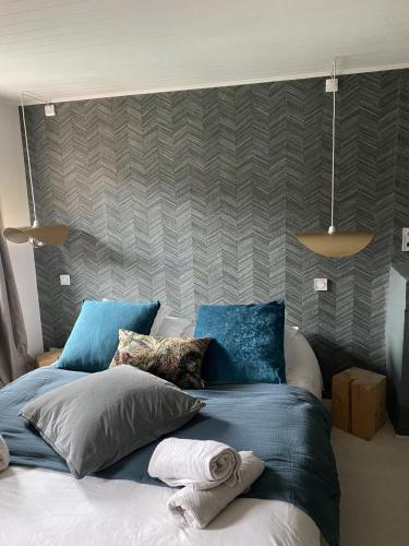 安锡“独特位置”舒适公寓的卧室内的一张带蓝色枕头的大床