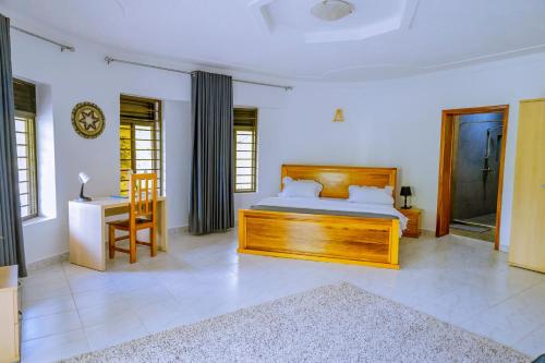 基加利Nature Kigali的卧室配有1张床、1张桌子和1把椅子