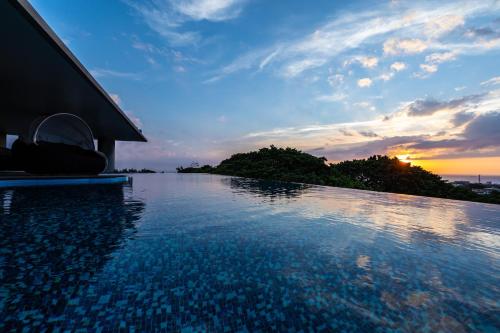 读谷村Glamday Style Okinawa Yomitan Hotel & Resort的一座享有日落美景的游泳池