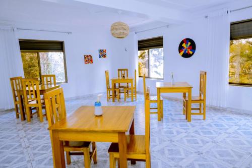 基加利Nature Kigali的用餐室配有木桌和椅子