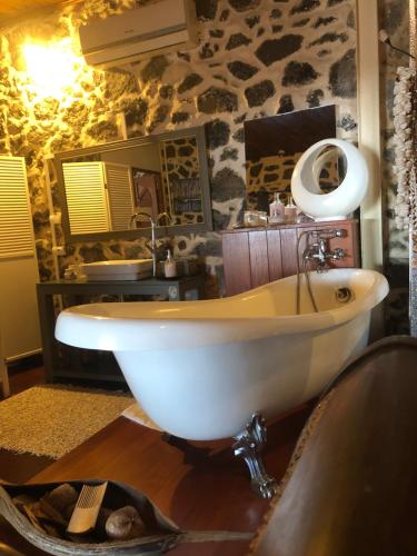 圣若瑟Les Grands Monts的石墙浴室内的白色浴缸