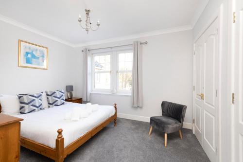 爱丁堡JOIVY Modern flat with free parking的卧室配有床、椅子和窗户。