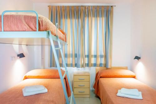 阿尔么丽亚阿尔伯格英特鲁文阿尔梅里亚酒店的一间卧室设有两张双层床和一扇窗户。