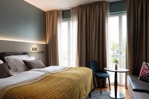 卡尔斯塔德Elite Stadshotellet Karlstad, Hotel & Spa的酒店的客房 - 带一张床、椅子和窗户