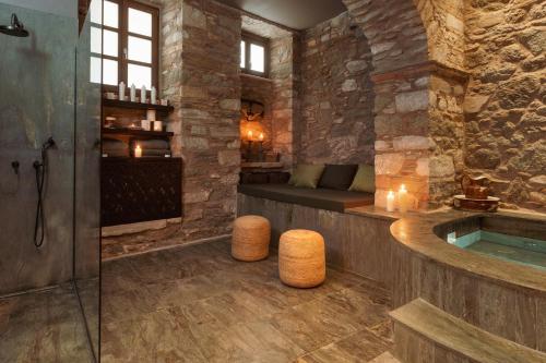 埃尔莫波利斯Castro Hotel Syros的一间石墙内带浴缸的浴室