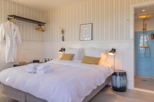 阿灵厄Allinge Badehotel的卧室配有带毛巾的大型白色床