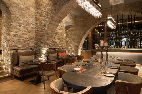 埃尔莫波利斯Castro Hotel Syros的餐厅设有一张大型木桌和椅子