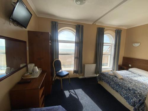 福克斯通OYO Gran Canaria Hotel的酒店客房设有一张床、一张书桌和窗户。