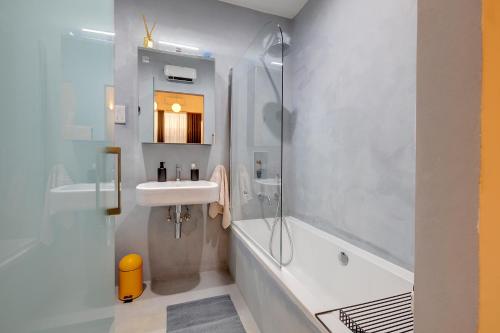 森格莱阿Traditional Maltese Townhouse wt Terrace and Pool的浴室配有水槽、淋浴和浴缸。