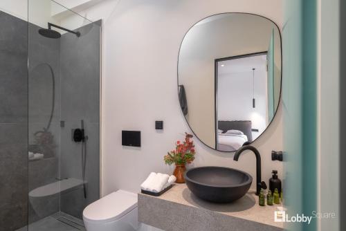 比雷埃夫斯La Mer Apartment by LobbySquare的浴室设有黑色水槽和镜子