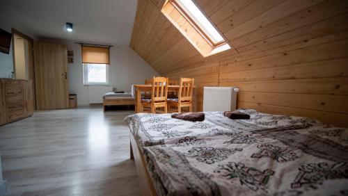 Zubrzyca GórnaU Jędrusia的木制客房内的一间卧室配有一张大床