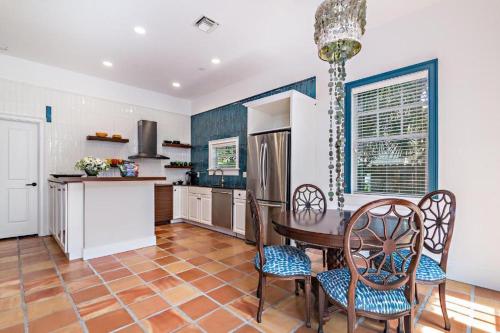 西棕榈滩Grandview Gardens的厨房配有桌椅和冰箱。