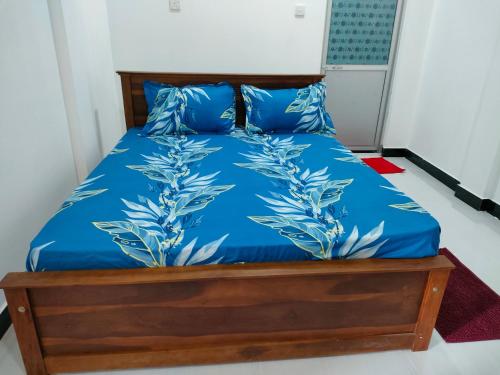 马纳尔Victory's Gardens的一张带蓝色床单和蓝色枕头的床