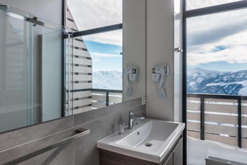 古多里Gogi Ski Resort的一间带水槽和镜子的浴室以及山脉