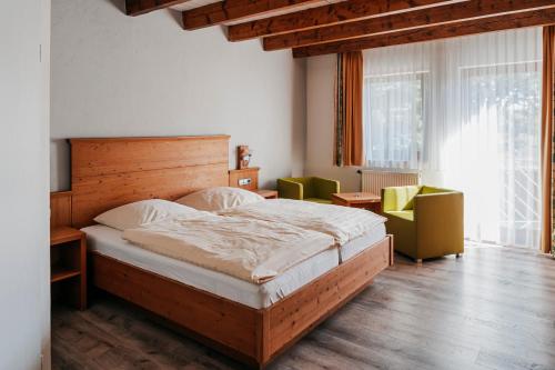 海德堡贝肯霍夫酒店 的一间卧室配有一张大床和两把椅子