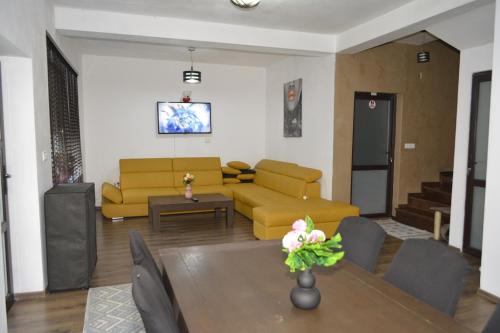 皮特什蒂Camere Centrale的客厅配有黄色的沙发和桌子