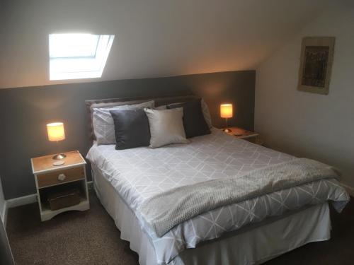 威尔斯浦Maesnewydd Cottage的一间卧室配有一张带2个床头柜的大床