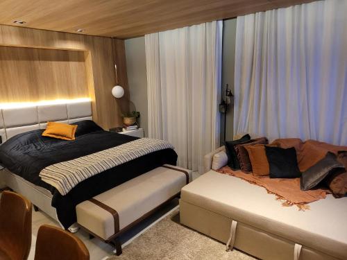 圣保罗Hotel Bourbon Ibirapuera Suite 5 estrelas Moema的一间卧室配有一张床和一张沙发