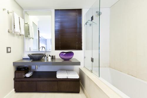 开普敦Hippo Boutique Hotel的一间带水槽和紫色碗浴缸的浴室