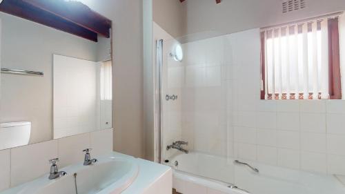 绍斯布鲁姆San Lameer Splash by Top Destinations Rentals的白色的浴室设有浴缸和水槽。