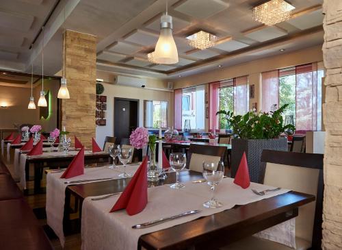 Biblis林登霍夫餐厅酒店的餐厅配有桌椅和红色餐巾