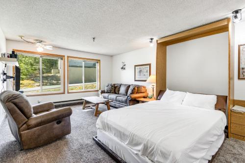 冬季公园Snowblaze Condominiums E103的一间卧室配有一张床、一张沙发和一把椅子