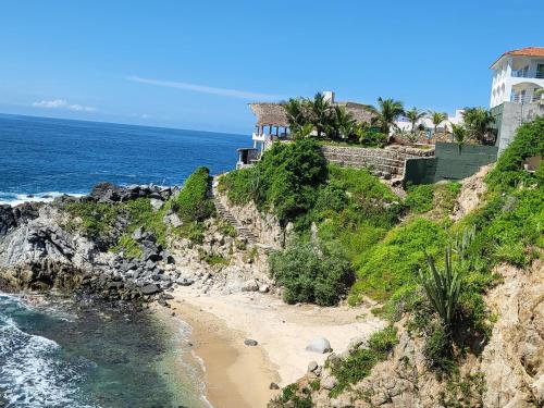 CuatunalcoHotel Luz de Mar ' right on the beach的海边悬崖上的房屋