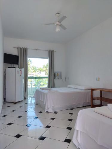 普拉杜POUSADA PRAIAMAR的白色的客房配有两张床和冰箱。