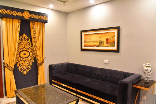 拉合尔Imperial Suites的客厅配有黑色沙发和黄色窗帘