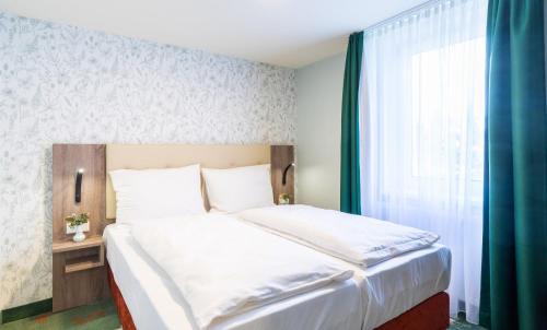 塞恩德Hotel & Restaurant Hubertus Sehnde的一间卧室设有一张大床和一个窗户。