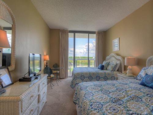 德斯坦Surfside Resort的酒店客房设有两张床和电视。