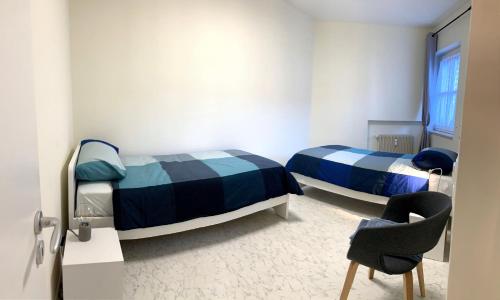 赖沙Hernegg Apartment的一间设有两张床和椅子的房间
